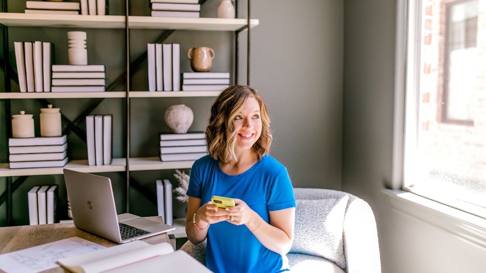 A solo marketing consultant working at a warm-lit desk with a laptop and notebook, illustrating the 2026 solo AI marketing operator.