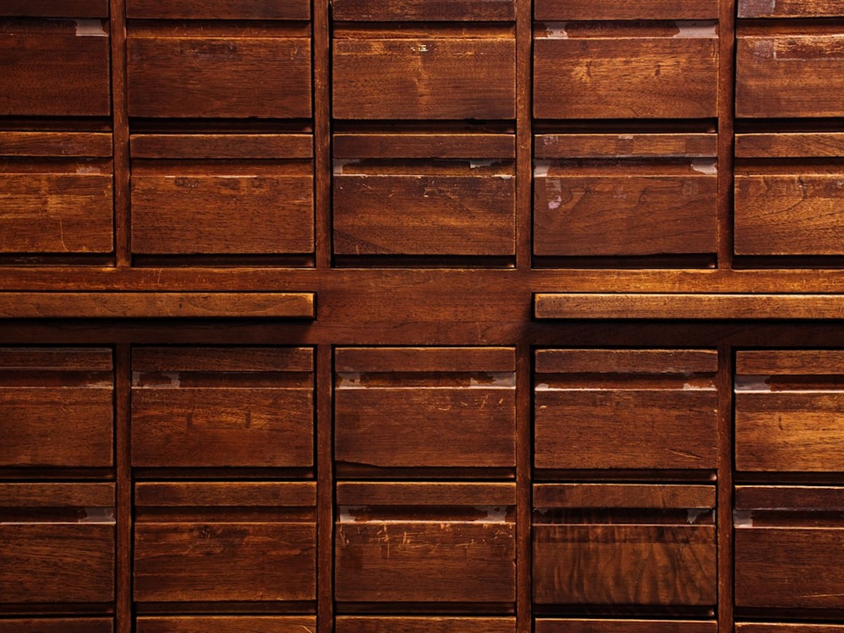 Oil painting of a wooden filing cabinet with drawers labeled Broad Match, Phrase Match, and DSA sitting empty while a new drawer labeled AI Max is opened